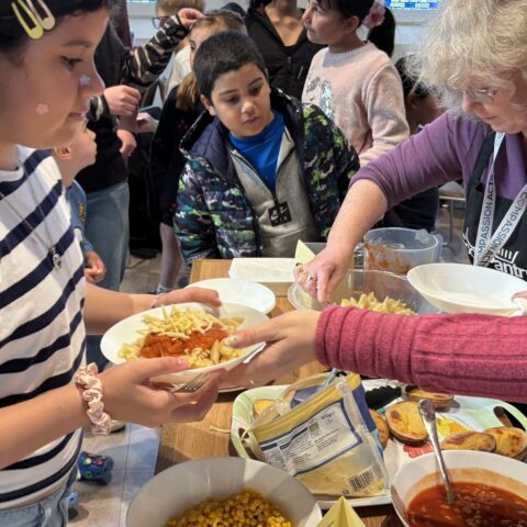 Image shows children enjoying food as part of a Feast of Fun activity