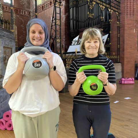 Fitness coach Fatima with class participant Jean holding weights, at St Dunstan's